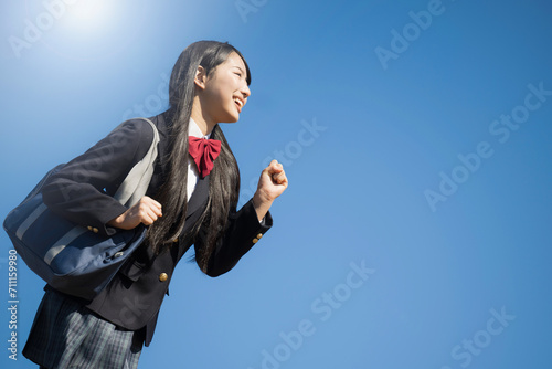 塾や予備校、大学受験に使いやすい 青空背景で笑顔で走る女子高生イメージ 頑張れ受験生！ photo