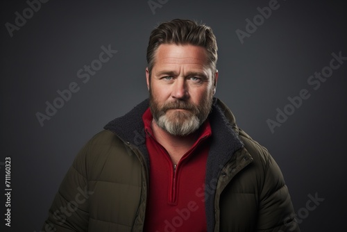 Portrait of a bearded man in a winter jacket. Studio shot.
