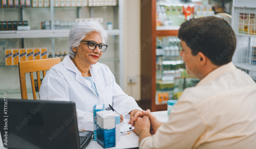 Pharmacist giving advice And advice for patients who come to buy Medicine, Drugs, Vitamins products, according to prescriptions in modern pharmacies.