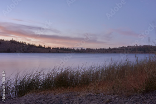 A painterly like scene over a lake with the moutnains in the distance as the sun sets near Mono Lake, California.