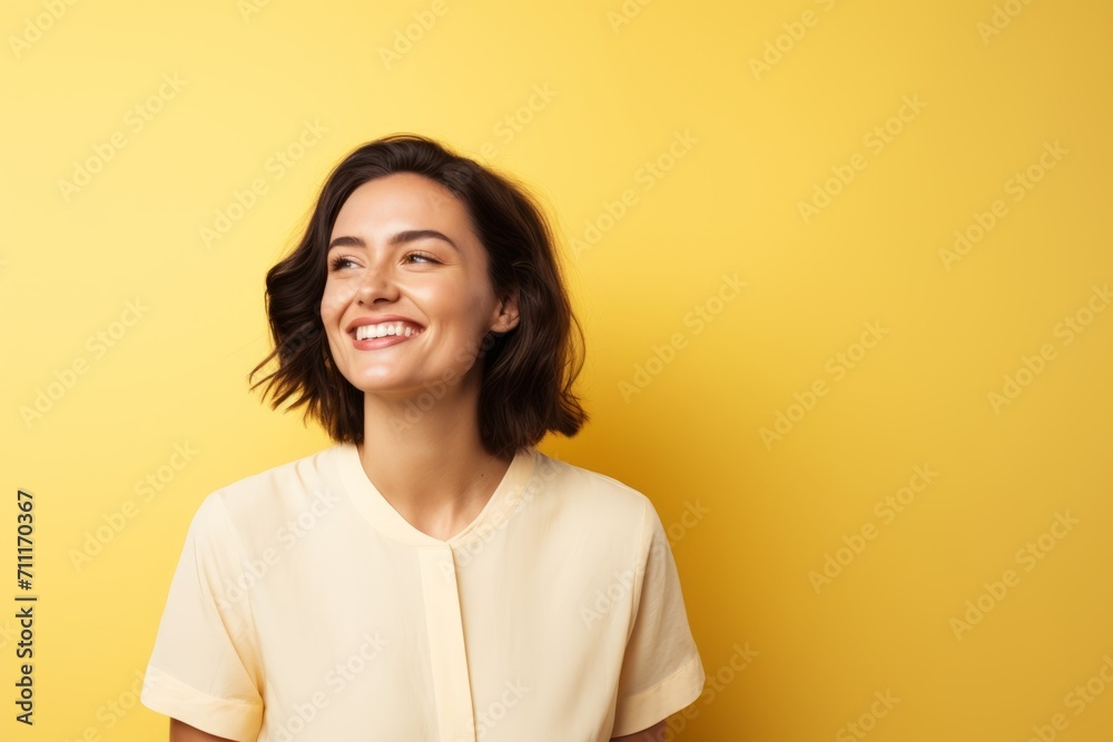 Portrait of a happy young woman looking at camera over yellow background Portrait of a happy young woman looking at camera over yellow background