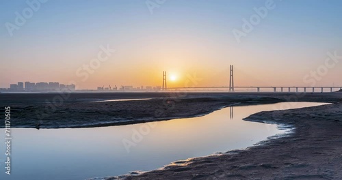 time lapse of the cable stayed bridge in winter sunset,  view from the north beach of Jiujiang second bridge during the dry season of the Yangtze River, China. photo