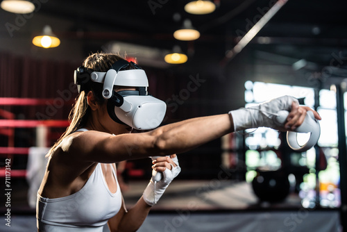Fototapeta Naklejka Na Ścianę i Meble -  Asian sportswoman using innovative technology VR glasses for exercise. 