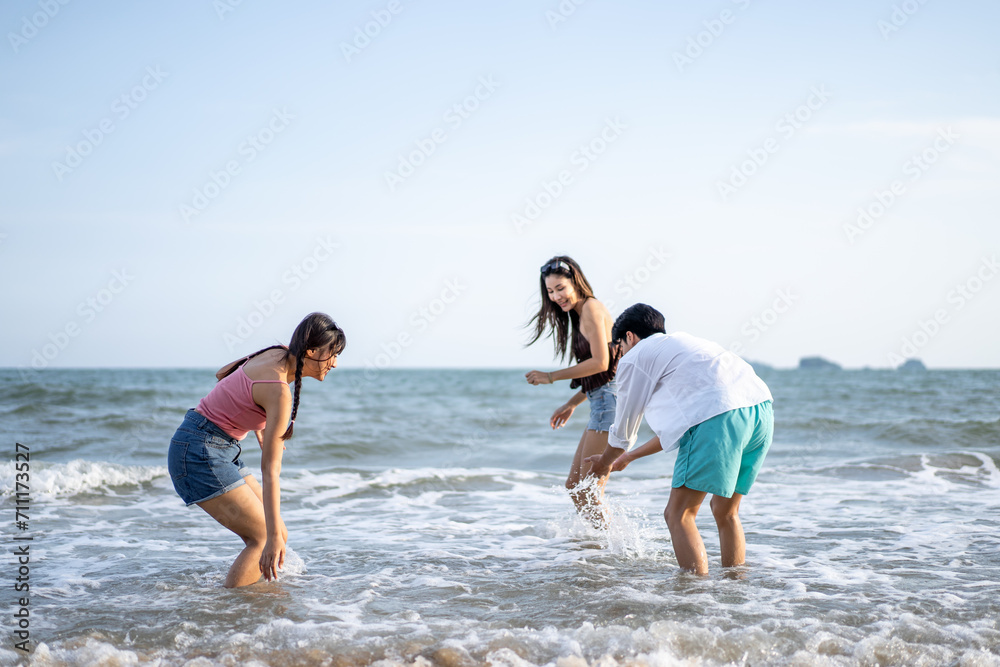 Group of Asian young man and women friend play on the beach together. 