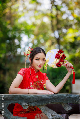 Chinese new year , Portrait of young asian woman with traditional Chinese  red drese in nature background, photo