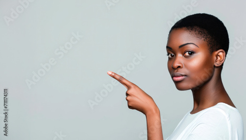 black beautiful woman points finger highlighting or giving directions on copy space photo