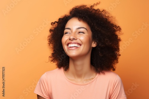 Portrait of a happy young african american woman on orange background