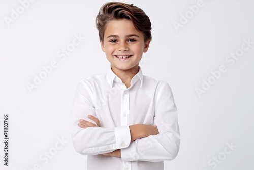 Portrait of a happy young boy with arms crossed over white background