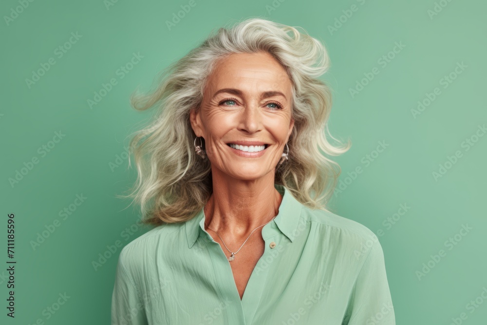 Portrait of a happy senior woman smiling at camera against green background Portrait of a happy senior woman smiling at camera against green background