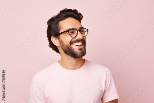 Portrait of young handsome hipster man in glasses over pink background © Inigo