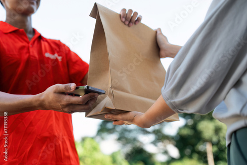 Asian young delivery man delivering package to female customer at home