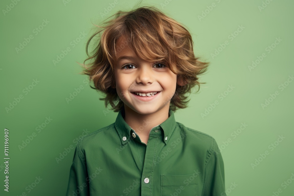 Portrait of a smiling little boy in green shirt over green background Portrait of a smiling little boy in green shirt over green background