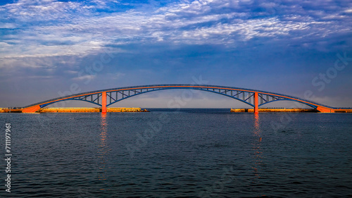 Amazing cirrus cloud view and beautiful arch iron bridge in the early morning form a scenic sea scene.High quality photo in Magong City, Penghu County, Use in branding, screensavers, websites, etc.