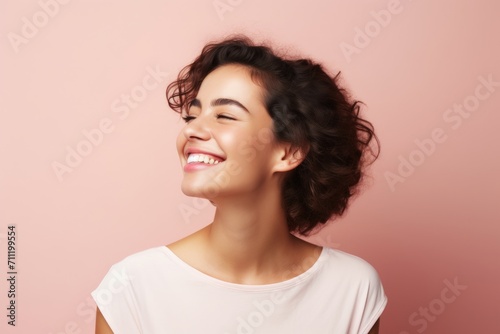 Beauty portrait of young happy smiling woman with curly hair, over pink background