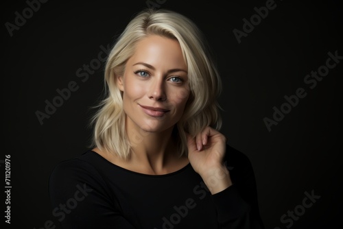 Portrait of a beautiful young blonde woman on a black background.