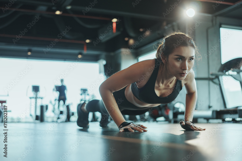 Sporty woman performing push-ups from the floor in the gym. Sporty woman performing push-ups from the floor in the gym.