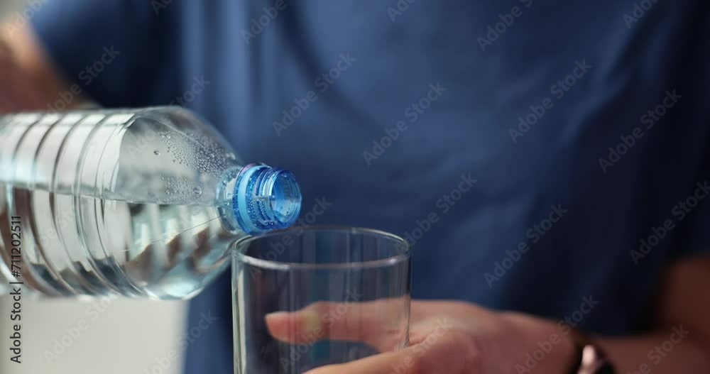Lady pours pure drinking water into transparent glass Lady pours pure drinking water into transparent glass