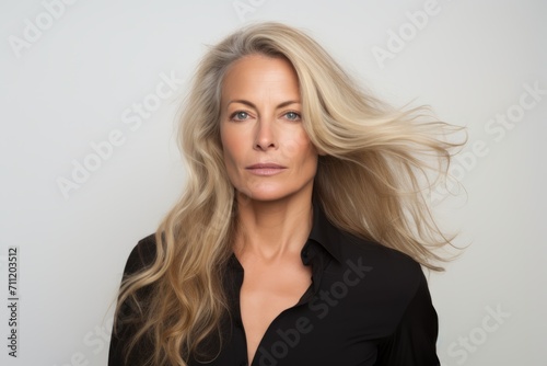 Portrait of a beautiful businesswoman with long blond hair, studio shot