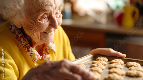 Happy elderly woman baking cookies at home. Senior people doing hobby and activity. photo