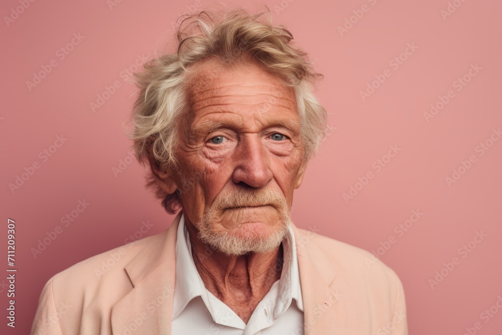 Portrait of an old man with grey hair on a pink background