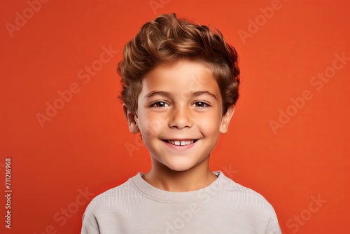 smiling little boy or cute child with curly hair on red background