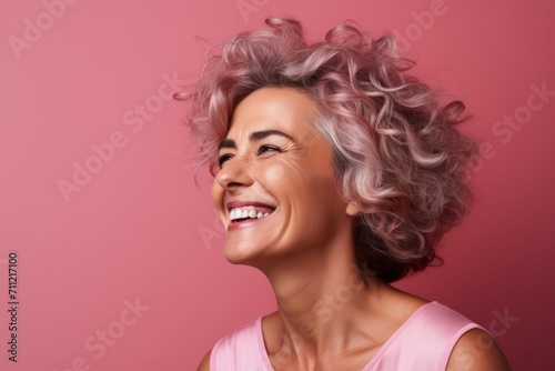 Portrait of a beautiful smiling woman with pink hair on a pink background