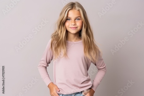 Portrait of a pretty little girl with long blond hair, wearing a pink sweatshirt.