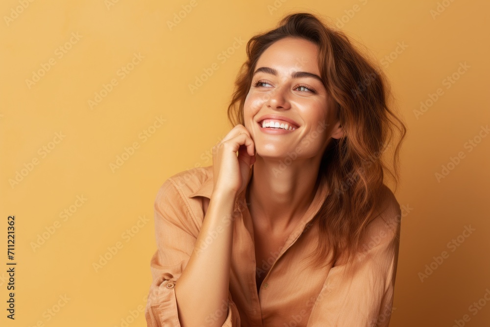Portrait of young happy smiling woman in beige shirt on yellow background Portrait of young happy smiling woman in beige shirt on yellow background