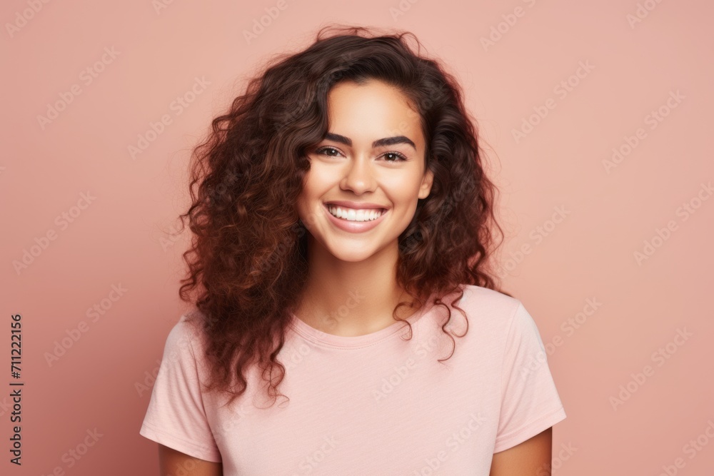 Portrait of happy smiling young woman with long curly hair over pink background Portrait of happy smiling young woman with long curly hair over pink background