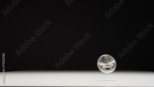 US Quarter Dollar Dropping Onto Table photo