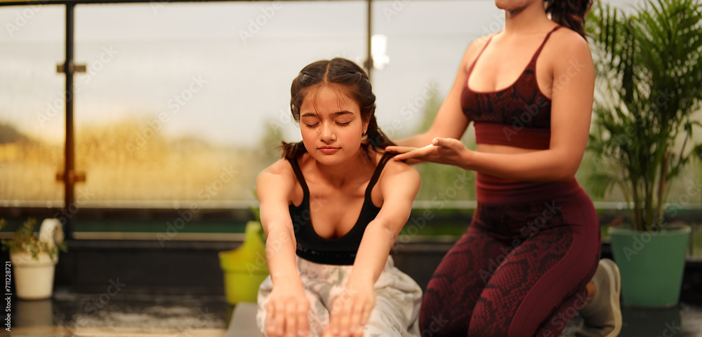 Obraz premium Indian Asian Hindu happy adult woman lady sitting on mat do toe touch yoga asana pose class day outdoor home gen z young sports female teach teen girl gym warm up self health care good habit