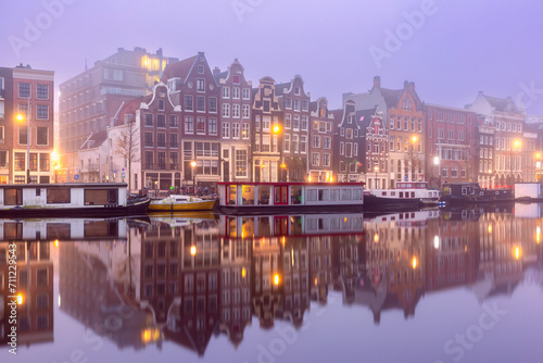 Foggy morning Amsterdam canal Amstel with typical dutch houses, Holland, Netherlands.