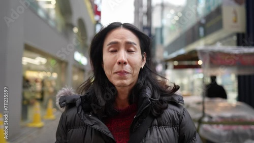 韓国のソウルの明洞の寒い冬の30代の韓国人男性のスローモーション映像 Slow-motion video of a Korean man in his 30s in the cold winter in Myeong-dong, Seoul, South Korea photo