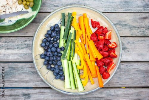 Plate of fruits and vegetables on an outside table for a healthy summer snack.