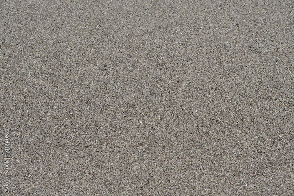 Fototapeta premium Sea sand top view flat lay. Gray sea sand on the seashore. Sea sand closeup flat lay.