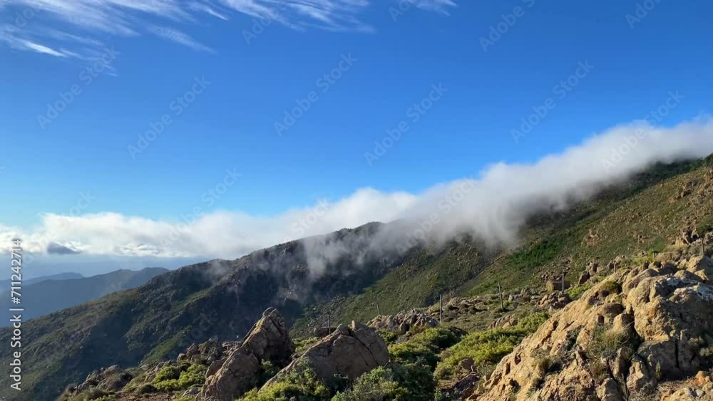 Cool rolling clouds on top of Sierra Bermeja mountain in Estepona Malaga Spain, green nature park, sunny day and blue sky, 4K shot Cool rolling clouds on top of Sierra Bermeja mountain in Estepona Malaga Spain, green nature park, sunny day and blue sky, 4K shot