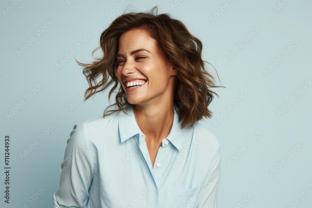 Portrait of happy smiling business woman in blue shirt, over blue background