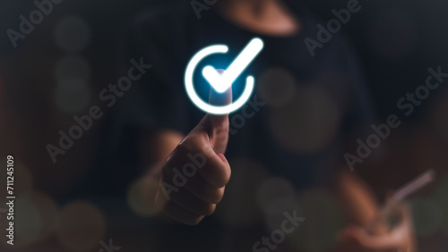 Hand thumb up with virtual correct sign or tick mark to approve quality assurance and guarantee concept.