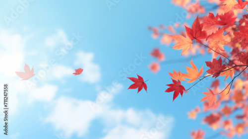 Red autumn leaves falling gracefully with a bright blue sky and fluffy clouds in the background.