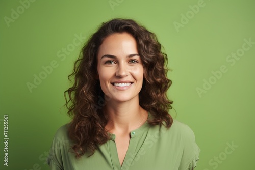 Portrait of a happy young woman with curly hair, over green background
