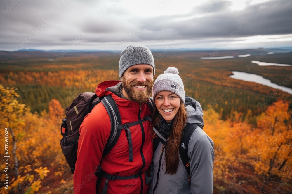 A couple captures a memorable moment as they pose for a selfie against a scenic wilderness background, Couple enjoys an autumn hike in Lapland, AI Generated