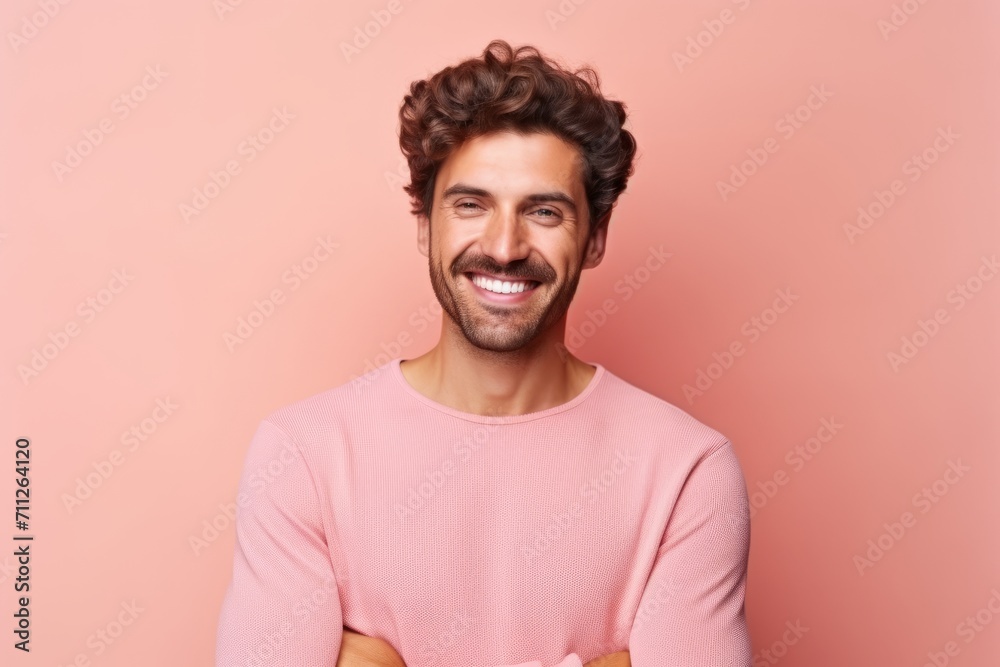 Portrait of a handsome young man smiling and looking at camera against pink background Portrait of a handsome young man smiling and looking at camera against pink background