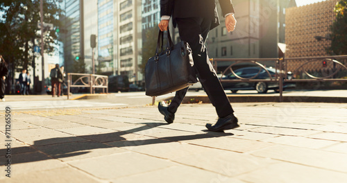 Legs, bag and business person walking, worker travel or commute to work in city with buildings. Corporate professional, sidewalk on urban street and journey to office with commuter in the morning photo