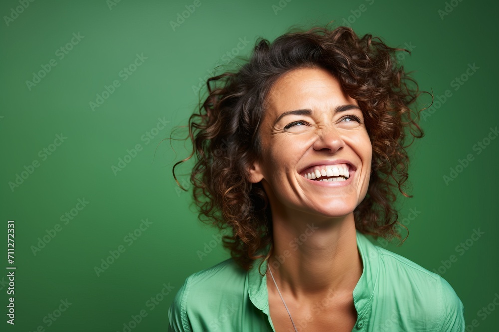 Portrait of a happy young woman laughing against a green background. Portrait of a happy young woman laughing against a green background.