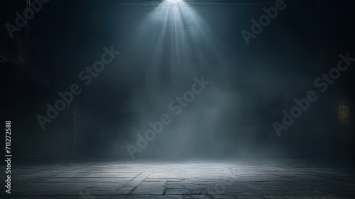 A dark room with a concrete floor and a spotlight. Suitable for dramatic or mysterious themed designs, theater and event promotion, and creative storytelling visuals. empty dark blue room photo