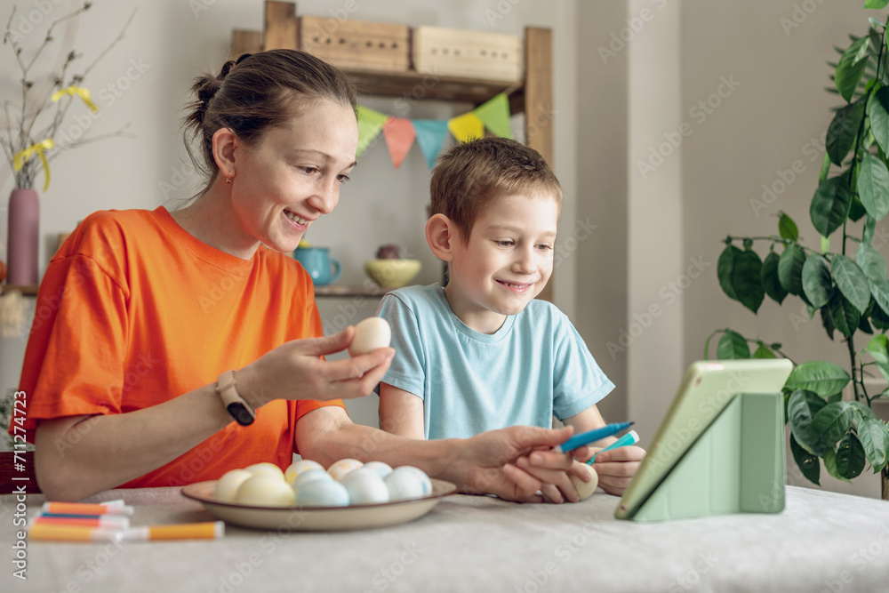 Happy Easter with your family. Mom and son are preparing for spring Easter by cheerfully coloring holiday eggs Happy Easter with your family. Mom and son are preparing for spring Easter by cheerfully coloring holiday eggs
