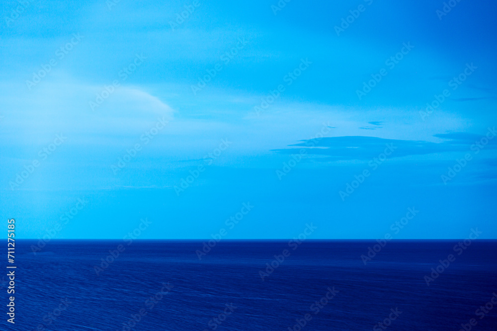 Fototapeta premium Landscape in blue with sea and cloudy dramatic sky