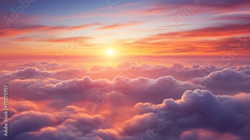 Aerial view of the sun setting over the clouds, creating a colorful and dramatic sky
