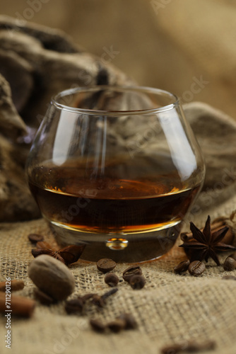 Glass of cognac with spice. Cloth background with copy space