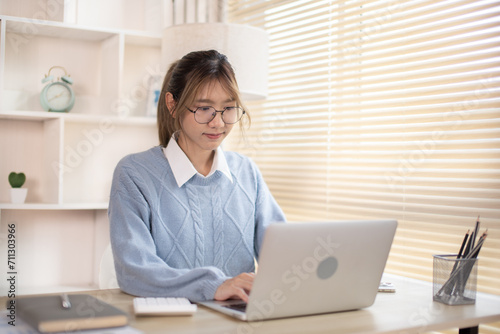 Woman typing in front of a laptop, Hand pressing laptop keyboard, Intention to work in the office.